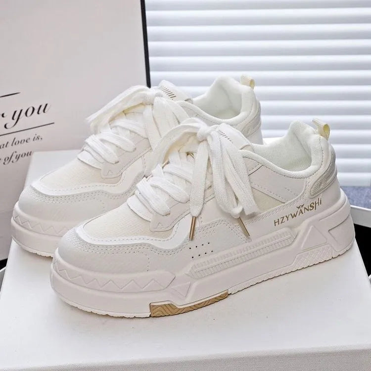 Children's beige platform shoes with front lace-up closure and an overfoot cross-strap on a thick rubber sole.