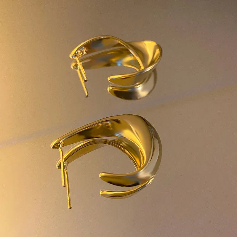 Metal twisted geometric earrings with round elements in gold or silver finish