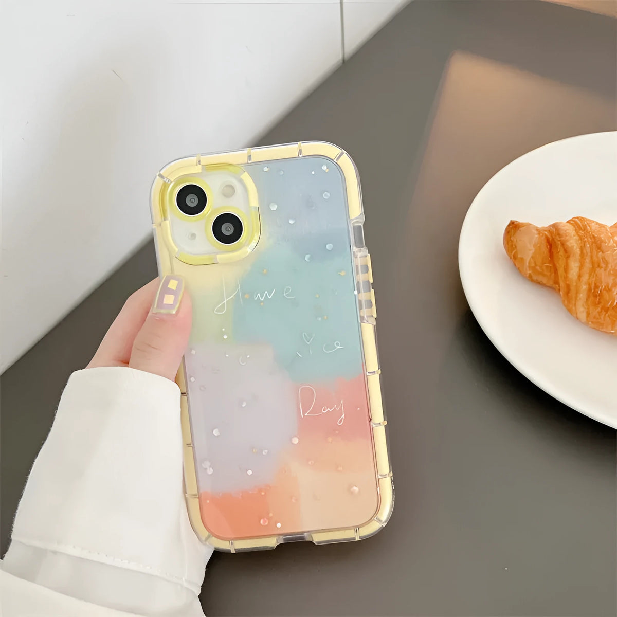 Slim minimalist silicone iPhone case with a yellow edge trim on a table.