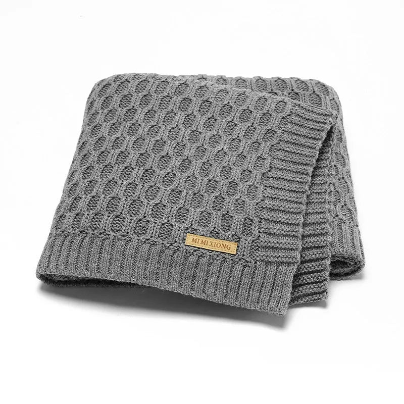 Infant hug blanket with three-dimensional lines pattern in a solid colour, measuring 70 by 90 centimetres.