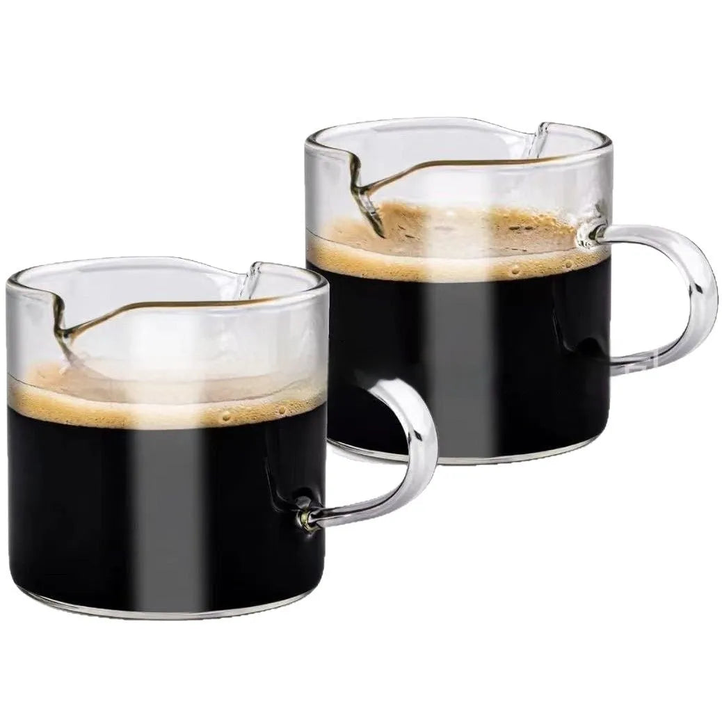 Transparent clear glass coffee cup with double spout design showing two drinking openings