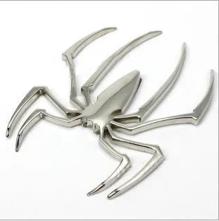 Three-dimensional metal spider bumper sticker in gold finish, measuring 7cm by 5cm.