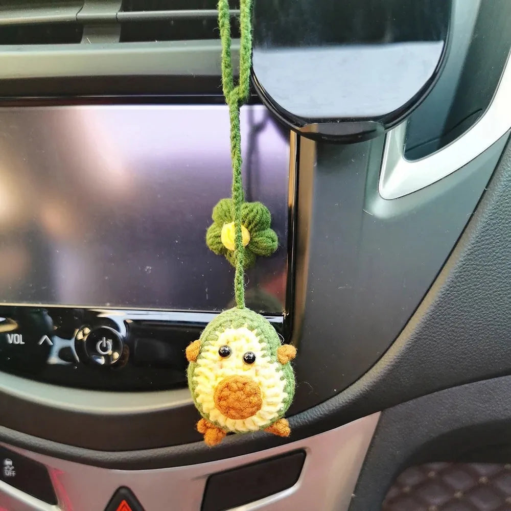Handmade crocheted avocado with rainbow flower car pendant in wool yarn.
