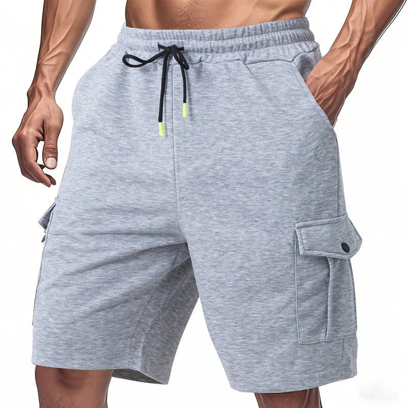 Man wearing light grey loose-fit cargo shorts made from textured towel fabric with multiple pockets.