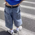Man wearing blue washed denim pirate shorts with a cropped length and high waist.