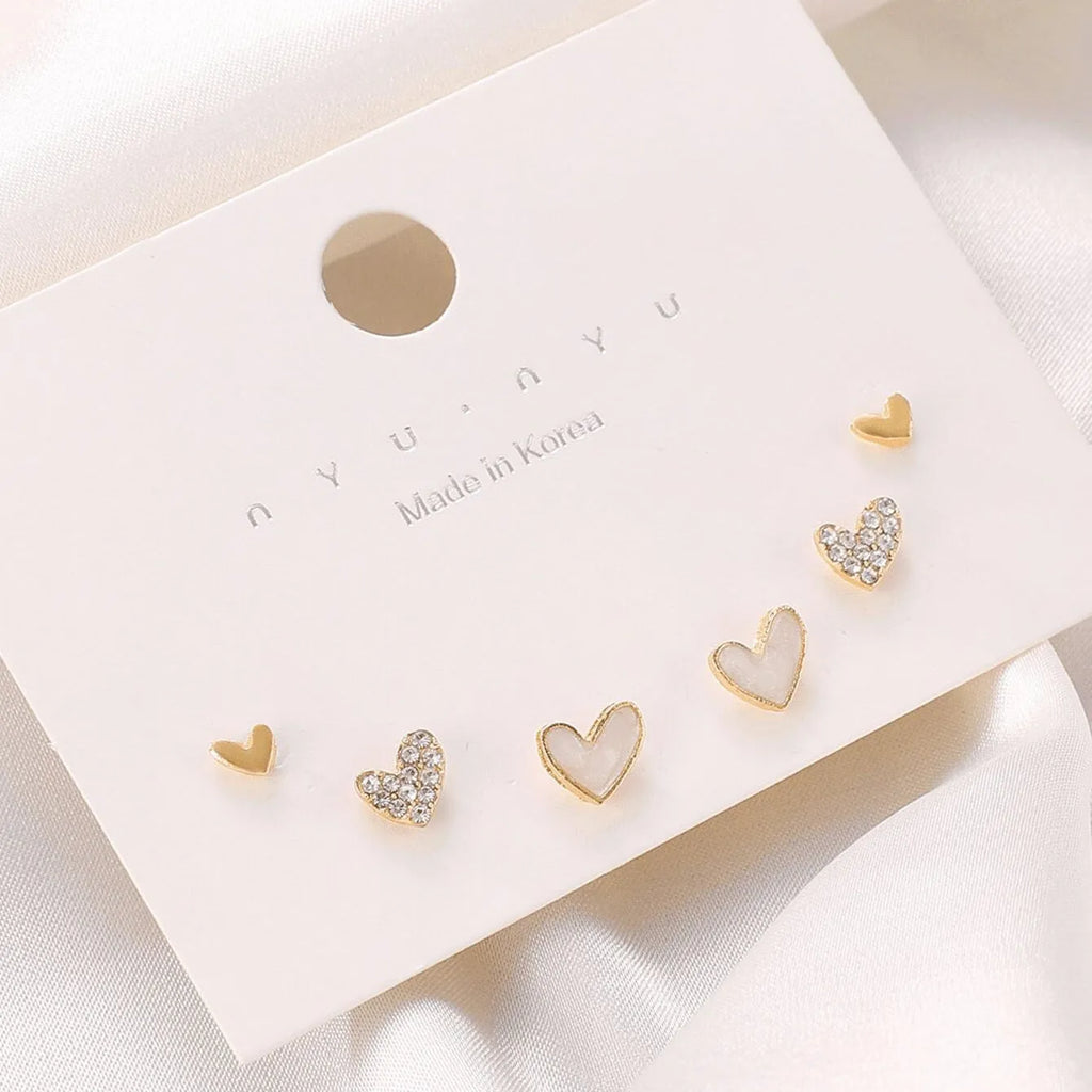 Women's three-pair heart-shaped love earrings set in gold, black, and pink colours with sweet girly style
