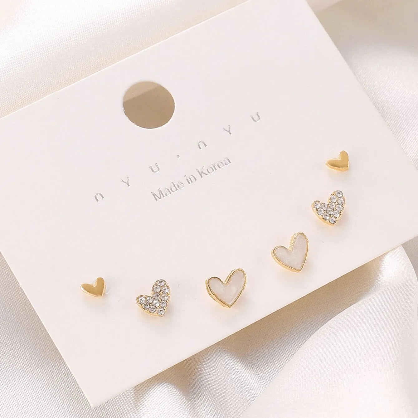 Women's three-pair heart-shaped love earrings set in gold, black, and pink colours with sweet girly style