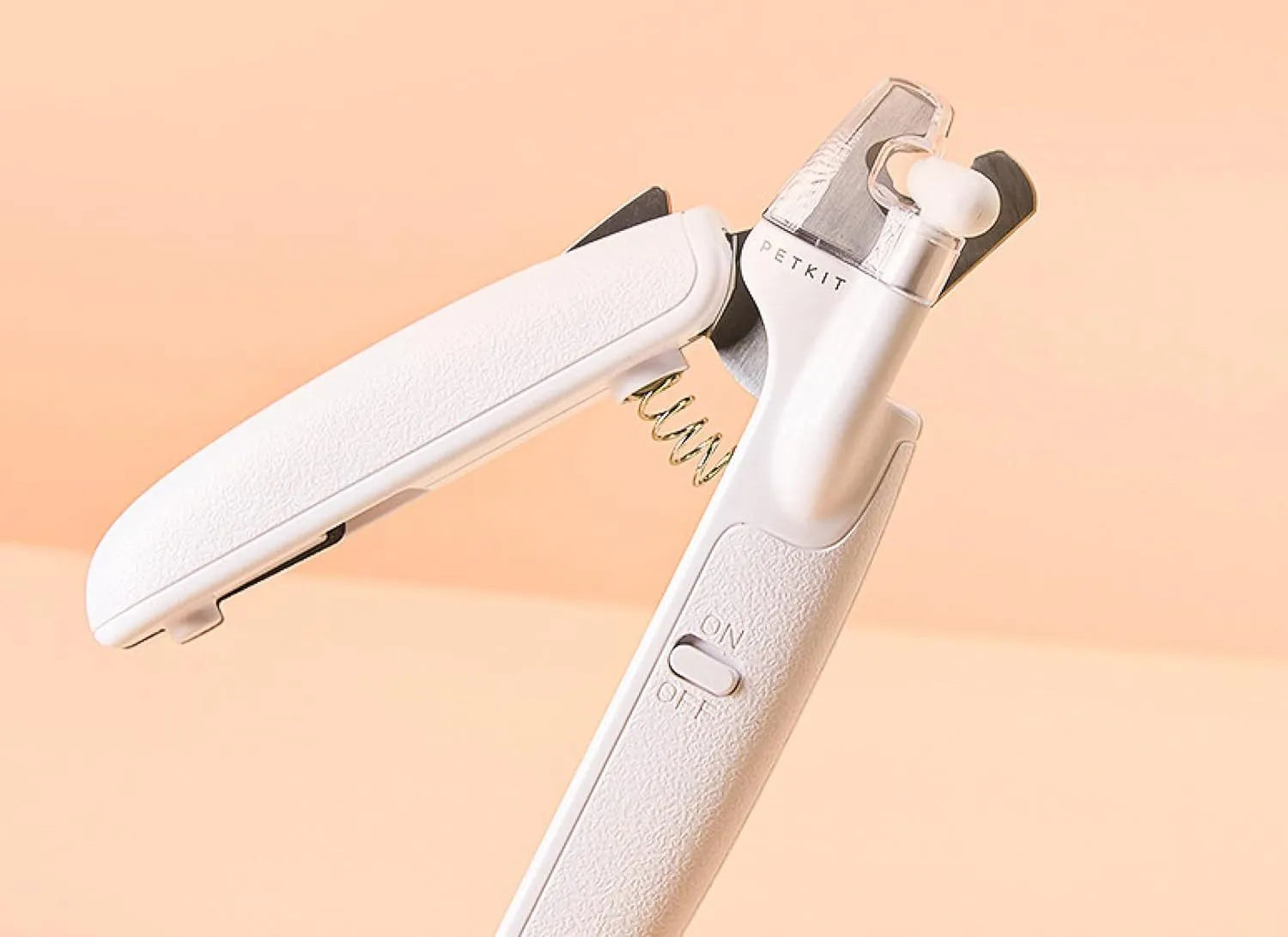 White LED pet nail clipper with transparent anti-splash guard open, showing triangular stainless steel blade