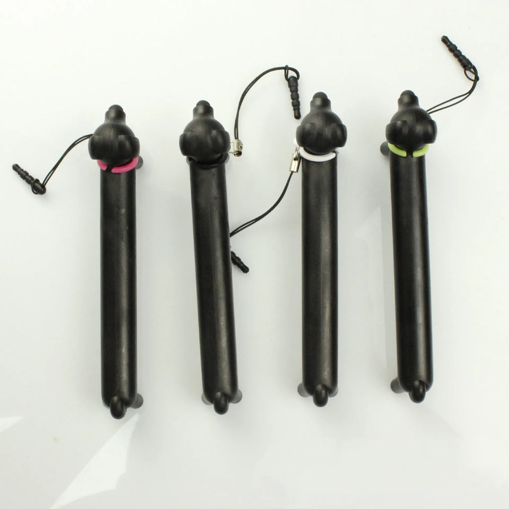 Black dog-shaped touch screen stylus pen shown next to a mobile phone on a desk.