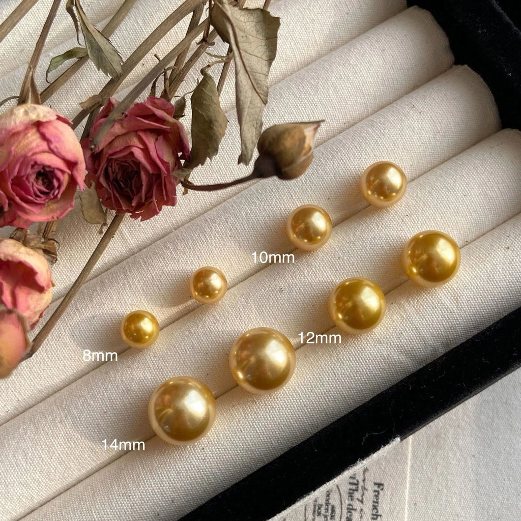 A pair of large geometric pearl stud earrings with an eight-awn star detail on silver settings.