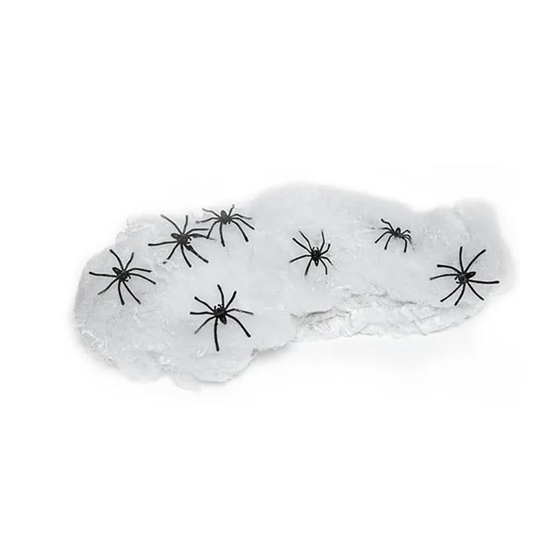 White cotton spider Halloween decoration web with plastic spiders draped across furniture