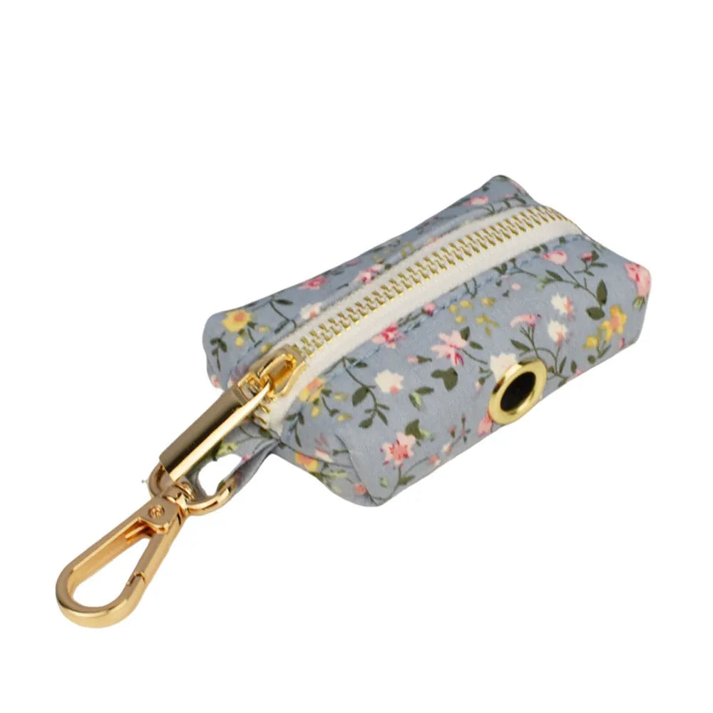 Blue floral patterned dog collar with matching accessories including leash, bow, vest, and poop bag