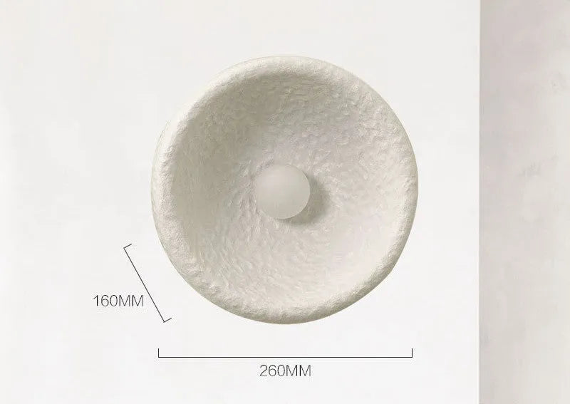 Japanese minimalist wall lamp in resin with warm light, showing three size options