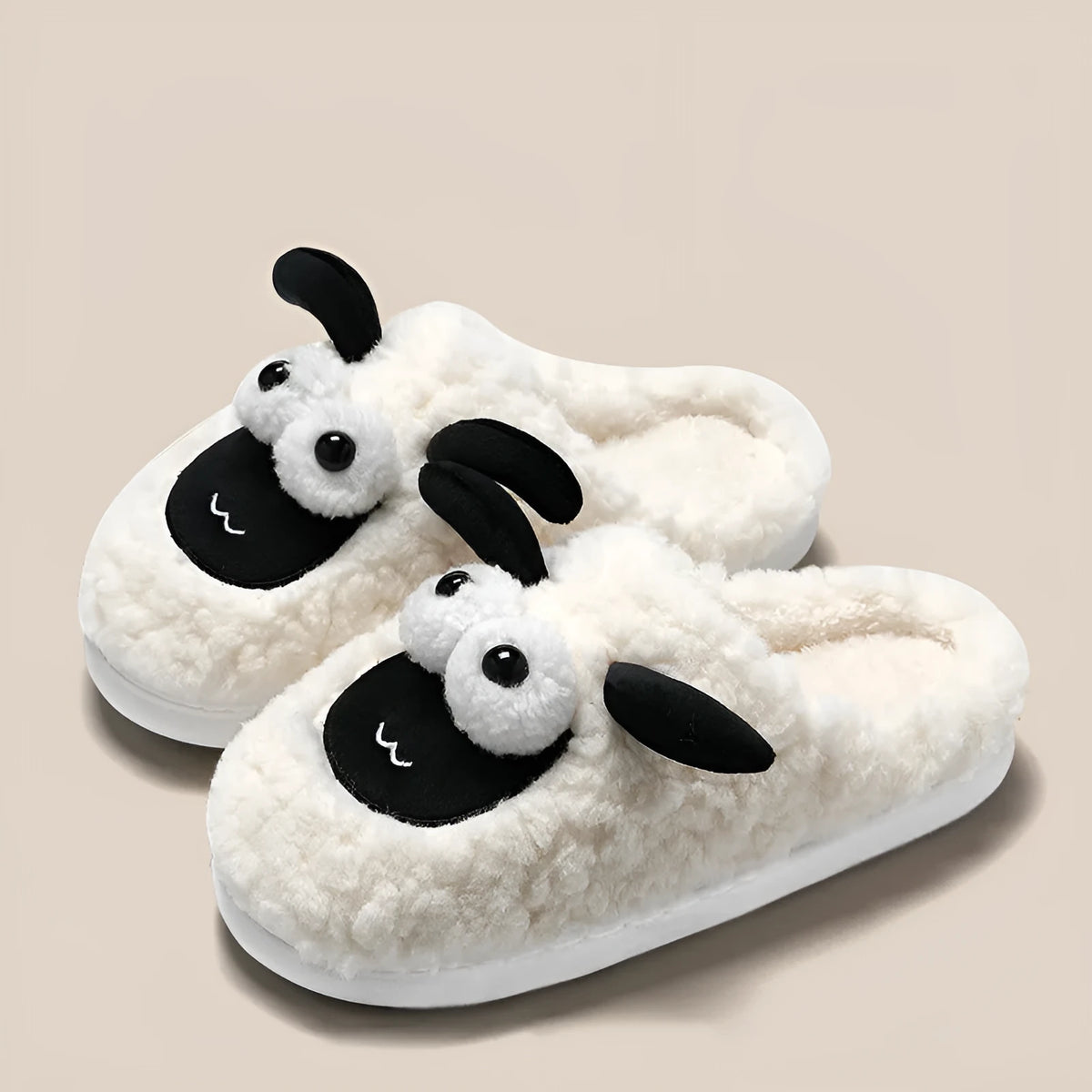 Brown suede slip-on slippers with a light-coloured sewn PVC sole on a wooden floor.