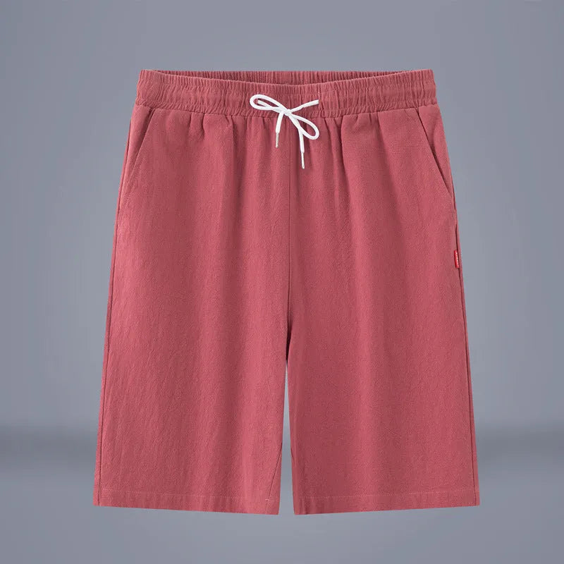 Man wearing solid colour cotton linen cropped trousers with a drawstring waist in a casual setting.