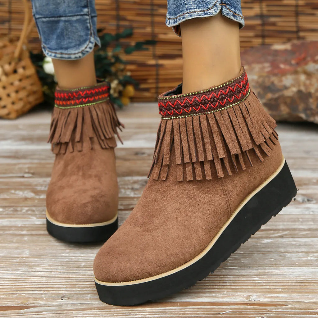 Women's black suede wedge ankle boot with side zip, tassel, and thick rubber sole.