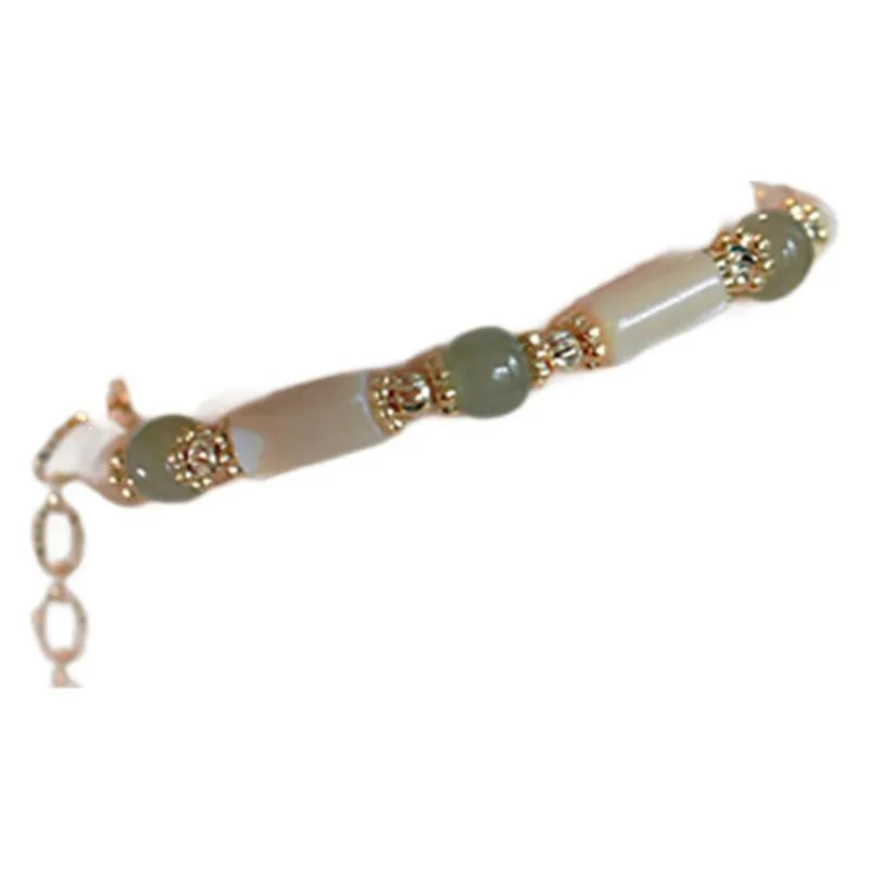 Simple geometric white Hetian jade bead bracelet for women on a wrist.