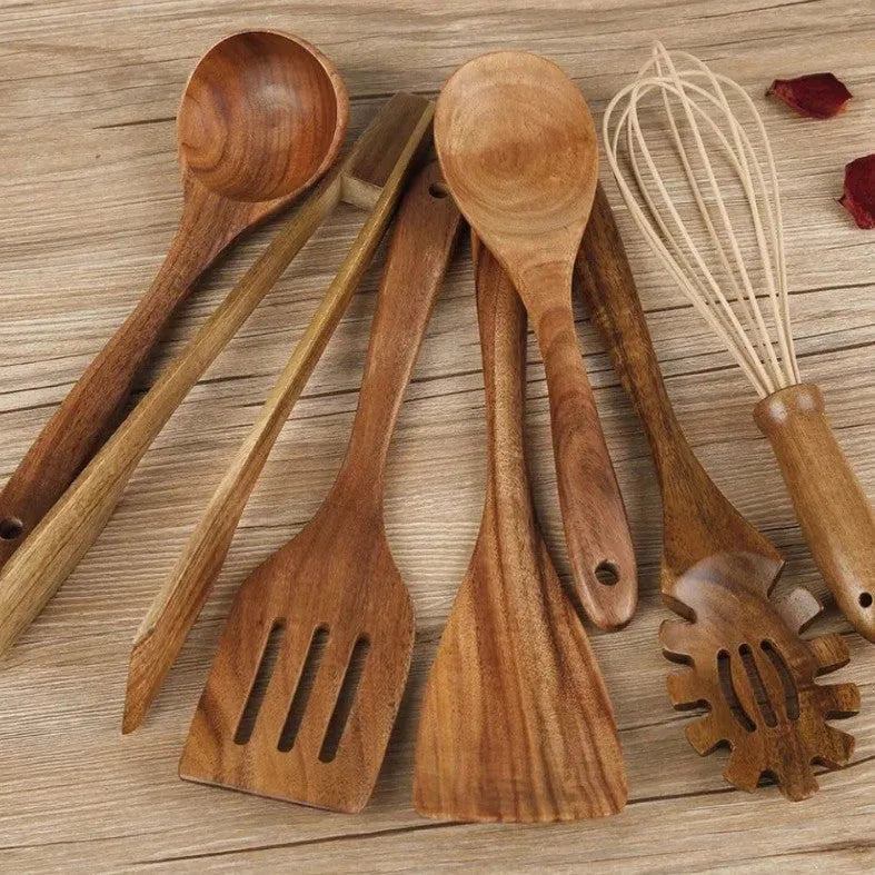 Seven wooden cooking utensils arranged together showing different shapes and sizes