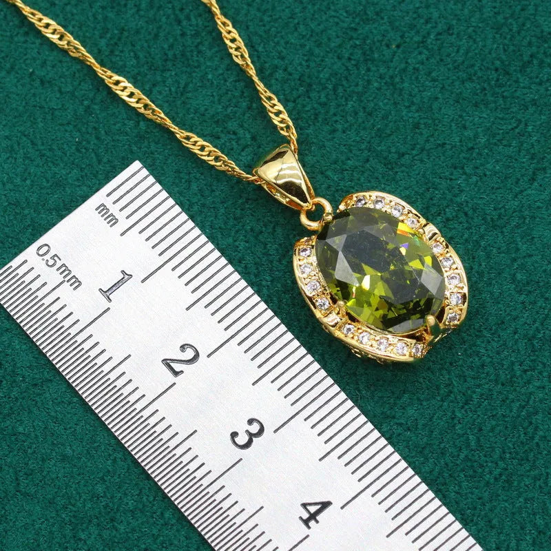 Olive green zircon stone jewellery set with cross, crown, and roman numerals pendant on a snake bones chain, plus matching earrings and ring.