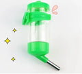 Green plastic ball kettle water feeder for small pets, attached to a cage, showing the drinking tube and ball valve.