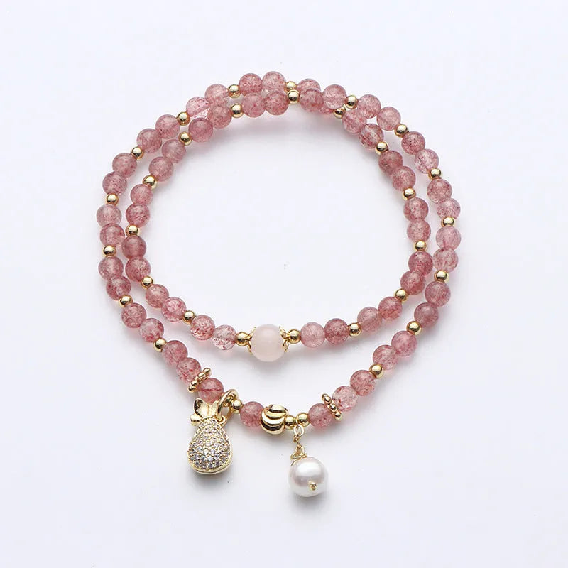 Close-up of a women's geometric bracelet made from pink strawberry quartz crystals.