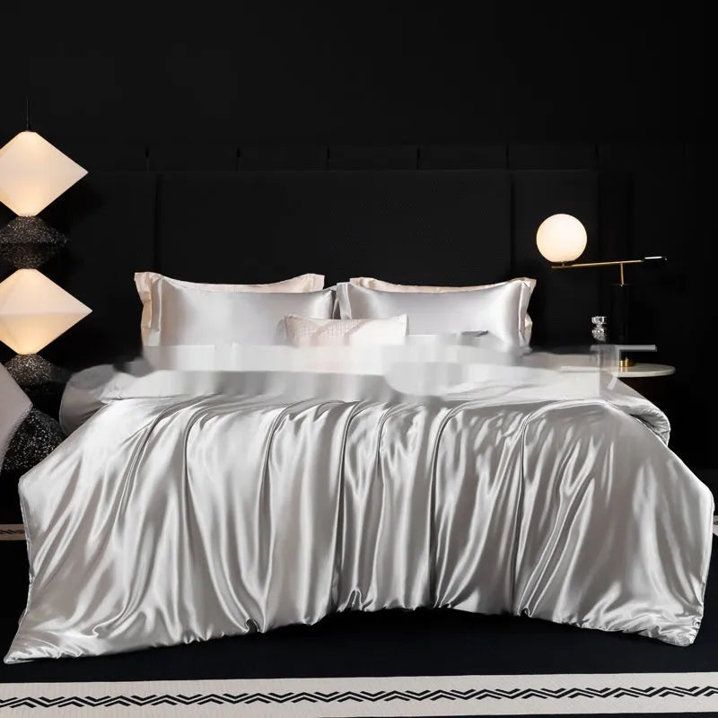 Silk four-piece bed sheet set in solid colour on bed with matching pillowcases and quilt cover
