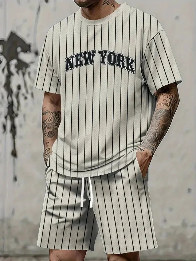 Man wearing a grey 3D printed letter design short sleeve top and matching shorts sports set.
