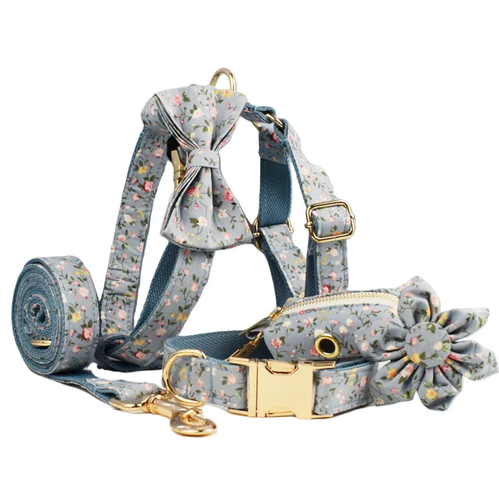 Blue floral patterned dog collar with matching accessories including leash, bow, vest, and poop bag