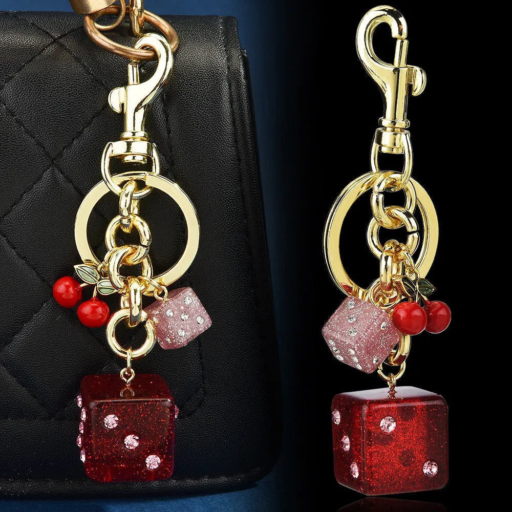 Square metal keychain pendant with a vintage cherry red and white dice design.