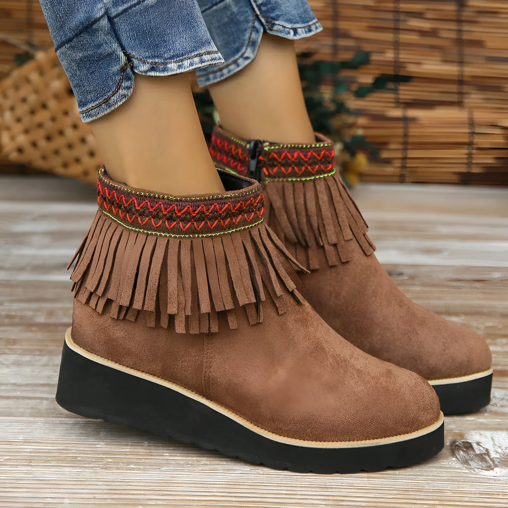Women's black suede wedge ankle boot with side zip, tassel, and thick rubber sole.