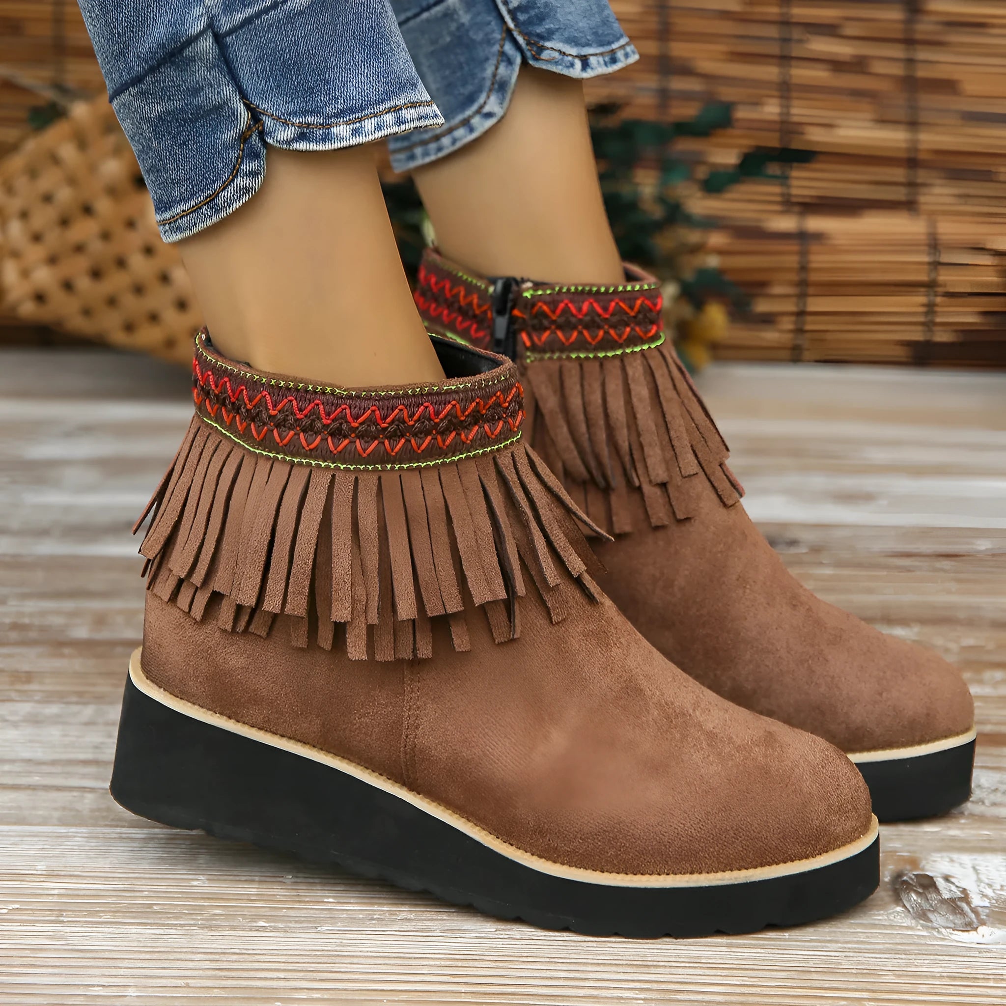 Women's black suede wedge ankle boot with side zip, tassel, and thick rubber sole.