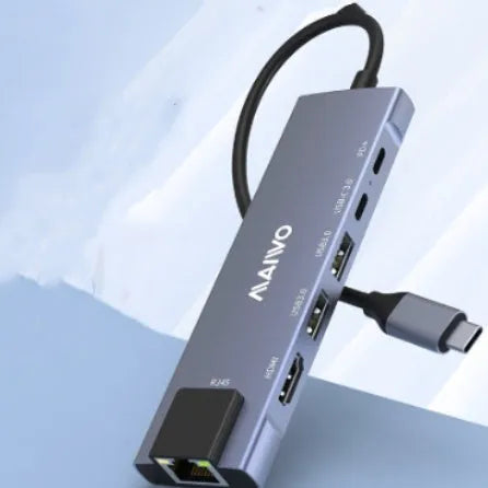 Steam Deck six-in-one aluminium docking station with HDMI, USB, and ethernet ports on a desk.