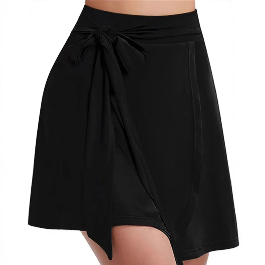 Black thigh-length sports skirt with built-in shorts showing high-waist culotte design and shoulder strap details