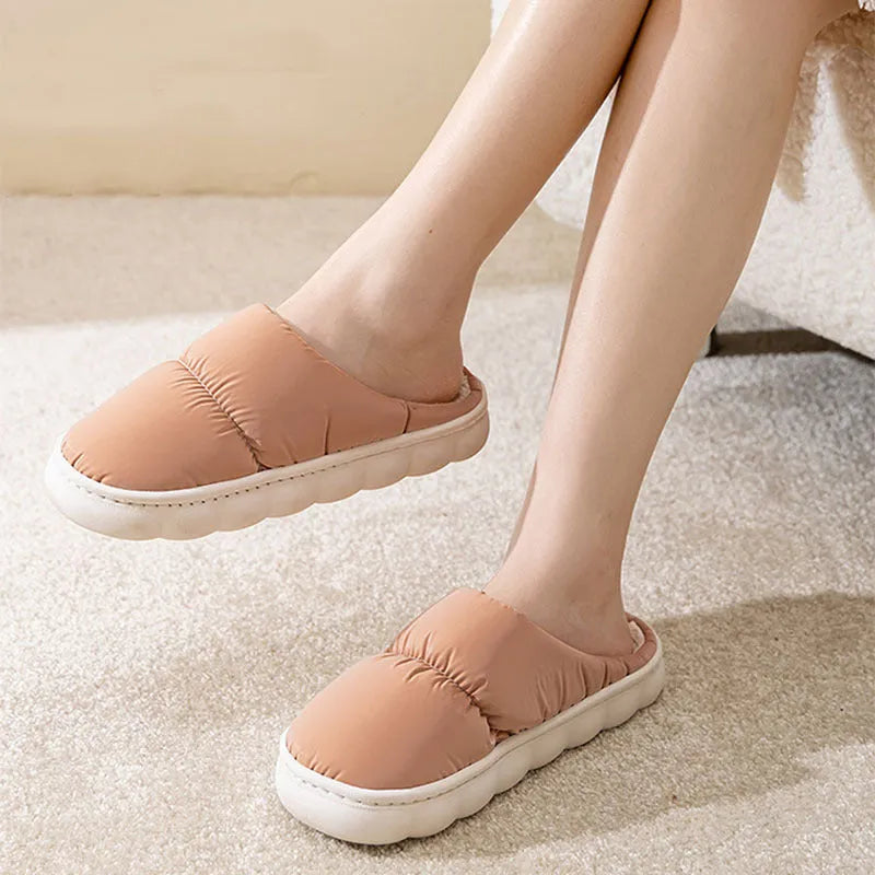 Blue winter indoor slippers with thick rubber sole and plush lining, shown on a hard floor.