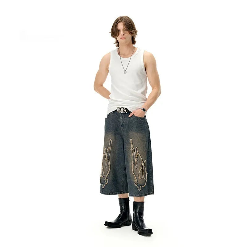 Men's black denim shorts with flame embroidery detail on straight-leg cut