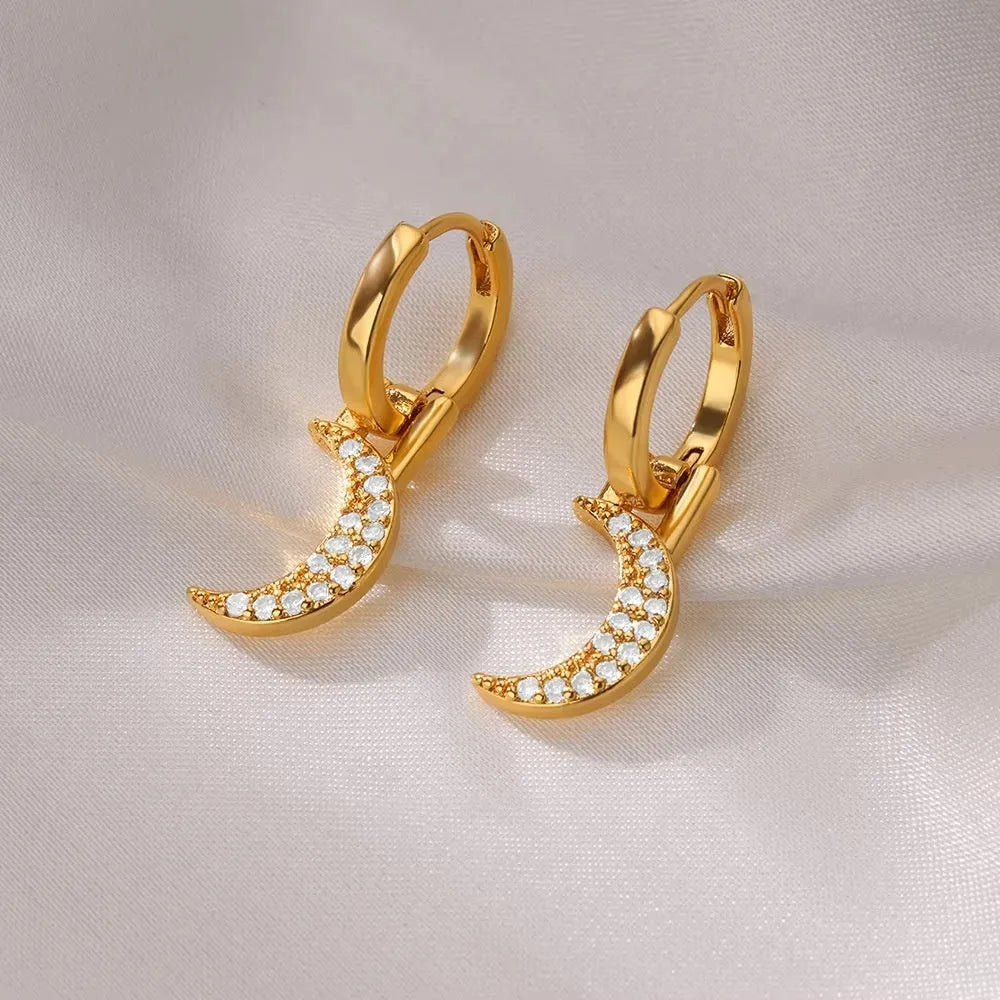 A pair of women's geometric butterfly earrings made from copper with heart, bow, and star shapes in a gold colour finish.