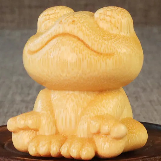Solid bamboo smiling frog carving ornament next to a 120ml oil glove brush.