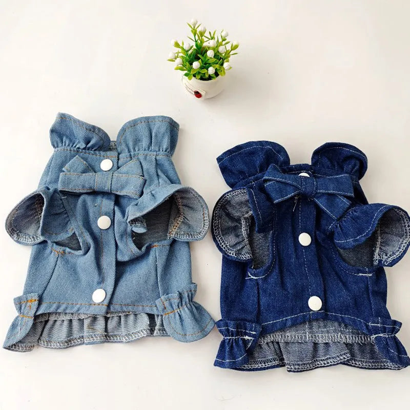Blue denim vest dress for dog with ruffle trim and metal leash hook on chest.
