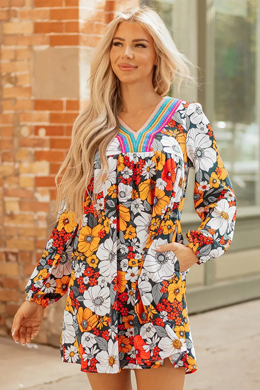 Orange floral print mini dress with lace trim, V-neckline, and long sleeves