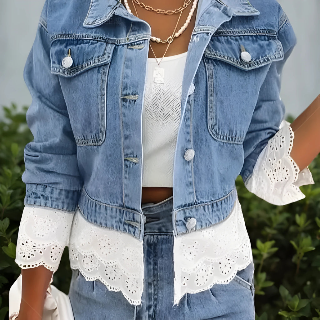 Blue women's denim jacket with lace stitching on the front, shown on a hanger.