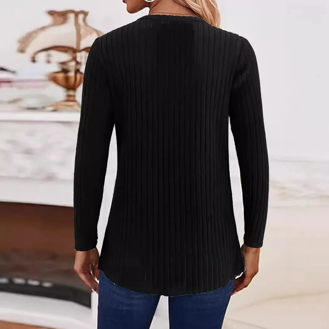 Simple solid colour knitted button sweater on hanger showing regular sleeves and button details