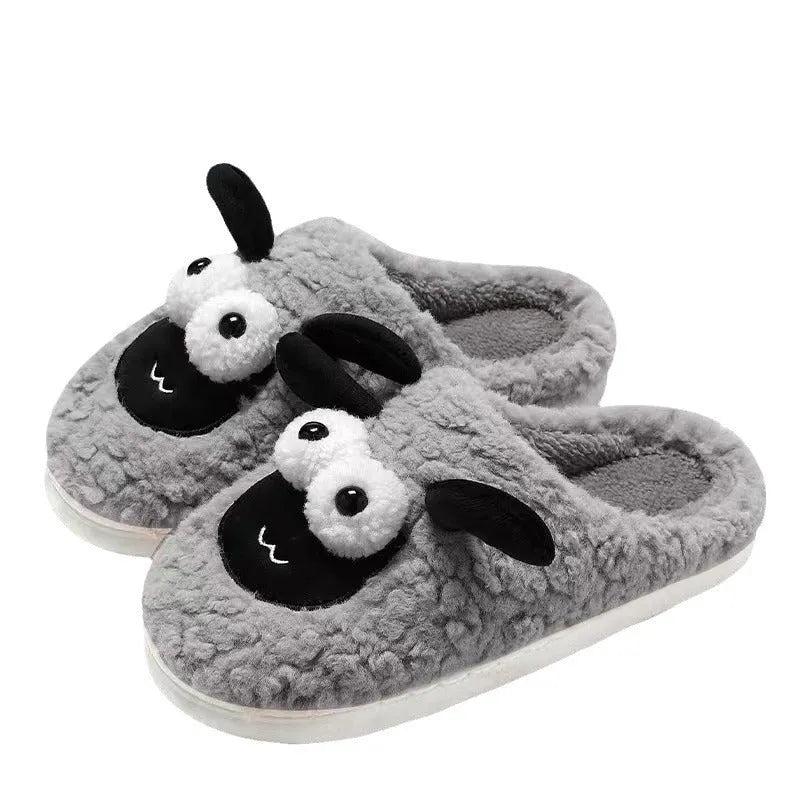 Brown suede slip-on slippers with a light-coloured sewn PVC sole on a wooden floor.