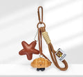 Handmade soda bread style handbag pendant with brown strap showing cartoon baked goods design