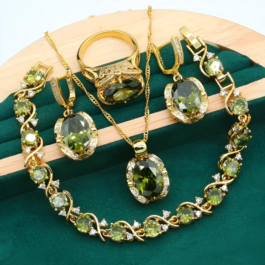 Olive green zircon stone jewellery set with cross, crown, and roman numerals pendant on a snake bones chain, plus matching earrings and ring.