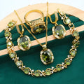 Olive green zircon stone jewellery set with cross, crown, and roman numerals pendant on a snake bones chain, plus matching earrings and ring.