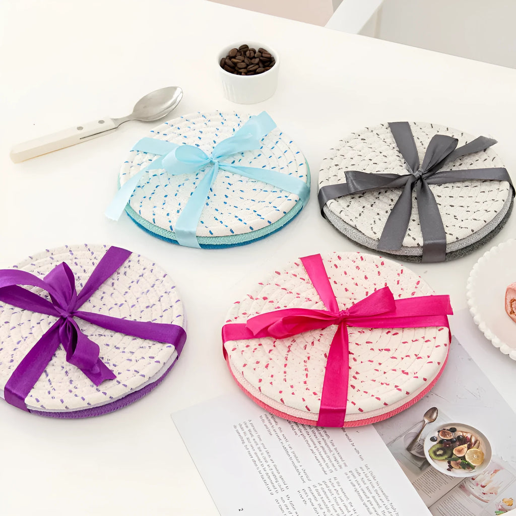Set of three round cotton cord coasters in blue colour, 18cm diameter, on a table.