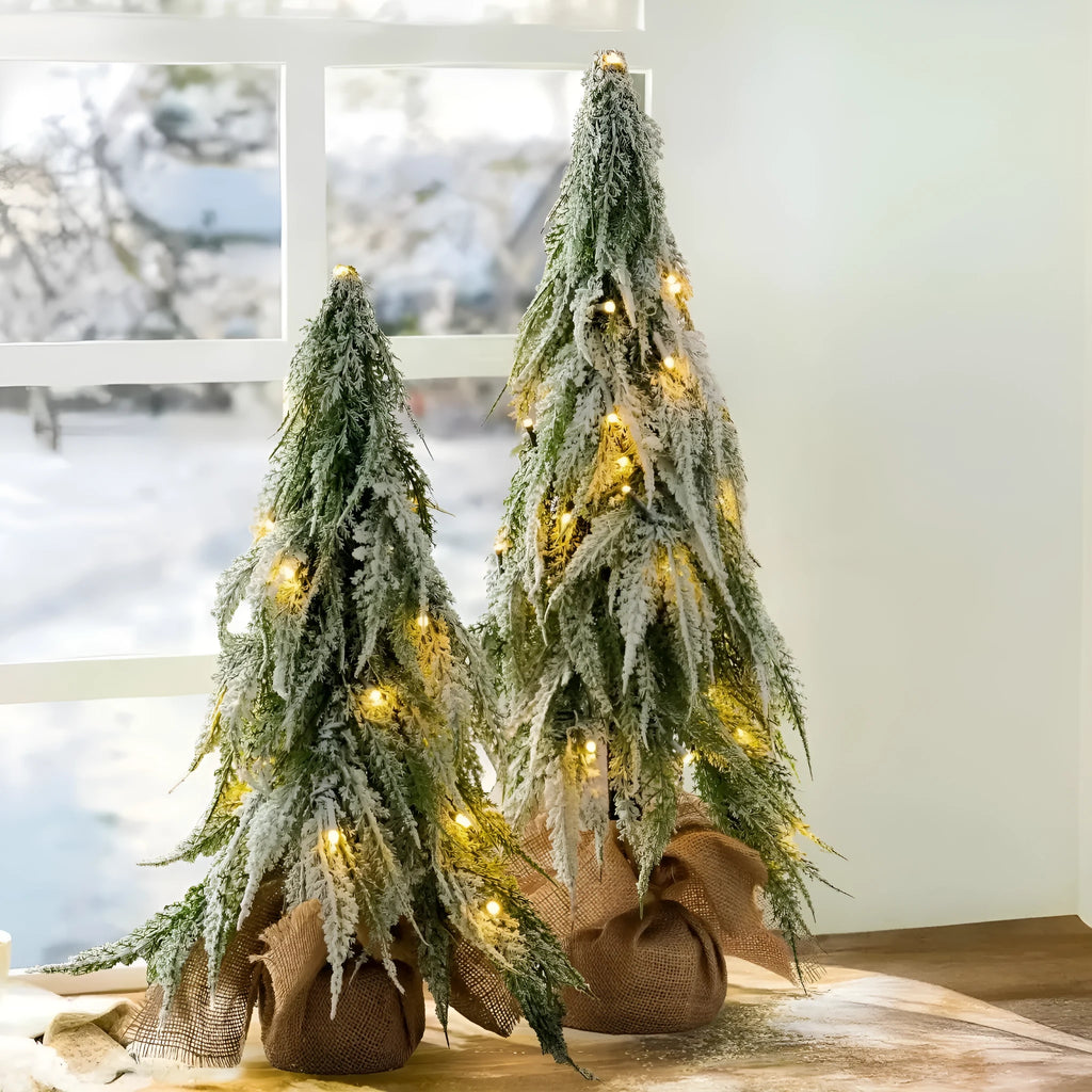 24-inch artificial Christmas tree with snow spray finish and integrated lights on desktop