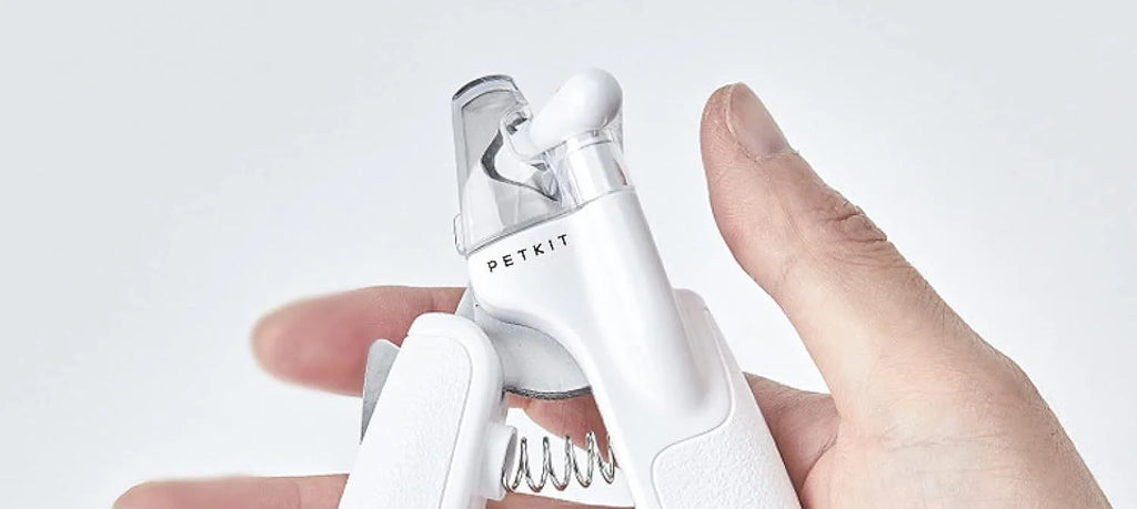 White LED pet nail clipper with transparent anti-splash guard open, showing triangular stainless steel blade