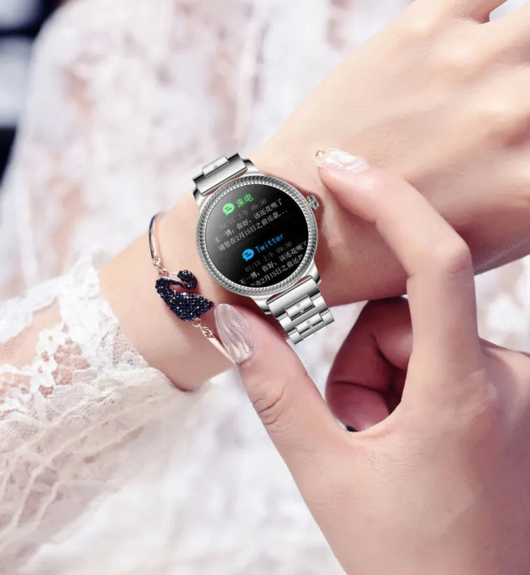 AK38 ladies smart watch with stainless steel band on wrist, showing its 1.09 inch colour screen.