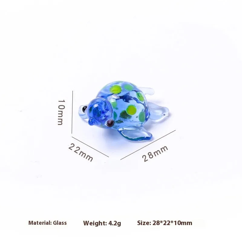 Glass geometric turtle ornament in blue head with blue shell colour variation on wooden desktop